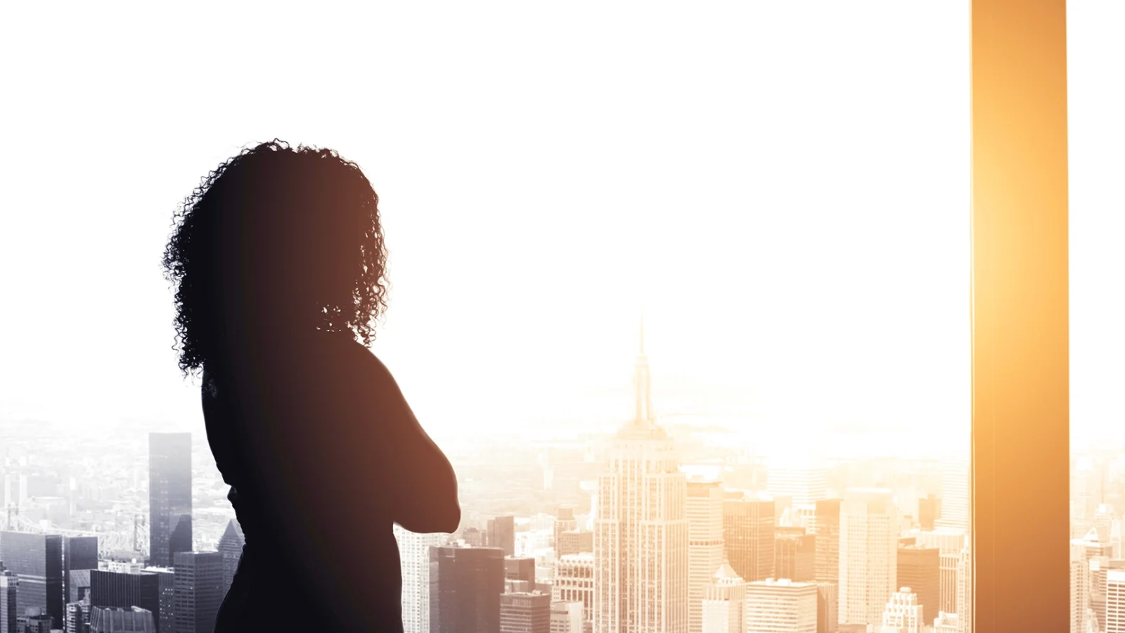 Black woman in office looking out window