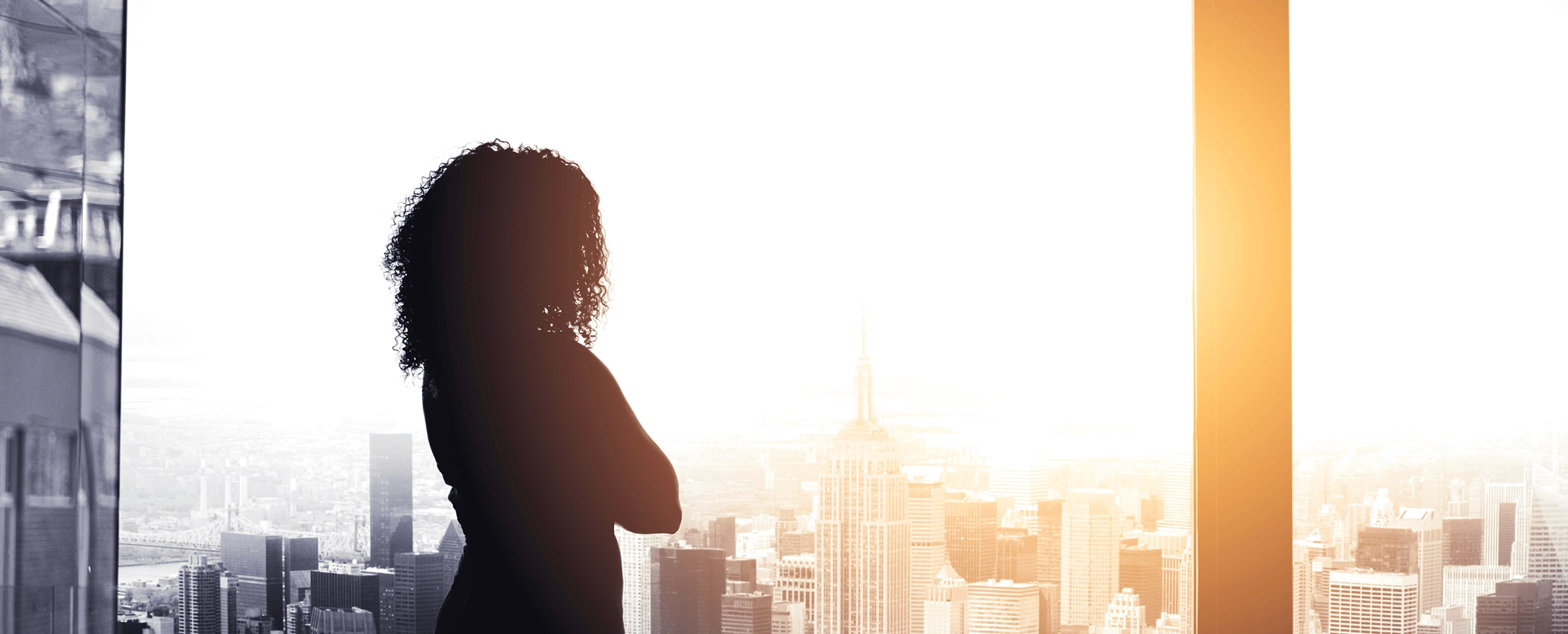 Black woman in office looking out window