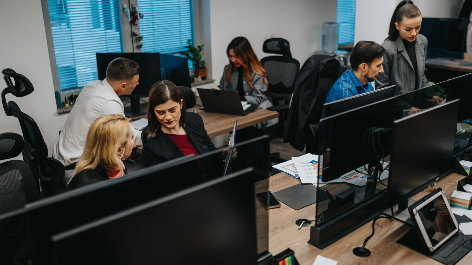 People communicating in busy office