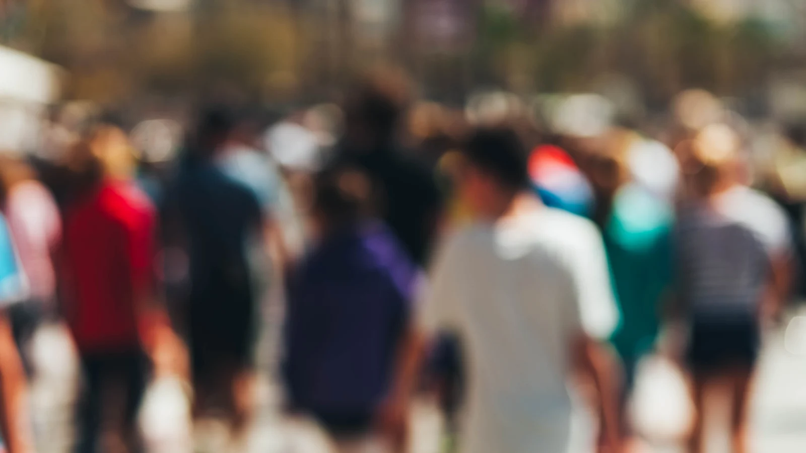 Blurry scene of diverse people walking on street