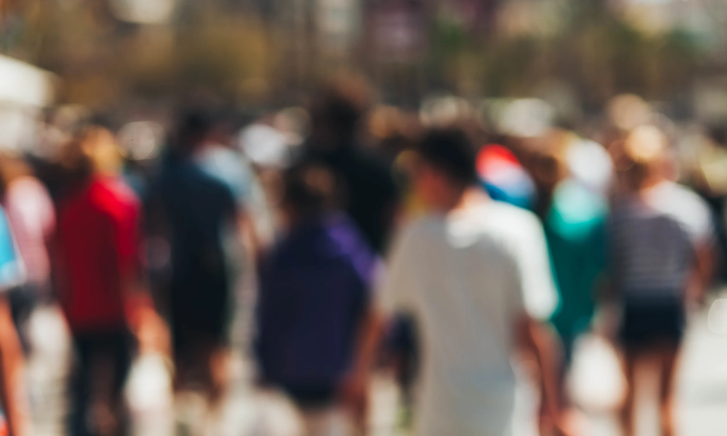 Blurry scene of diverse people walking on street